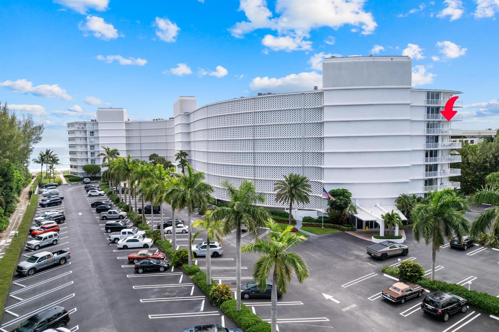 A large white multi-story residential building features a curved facade and a parking lot — 2780 S Ocean Boulevard # 612, Palm Beach FL 33480, PALM BEACH, FL
