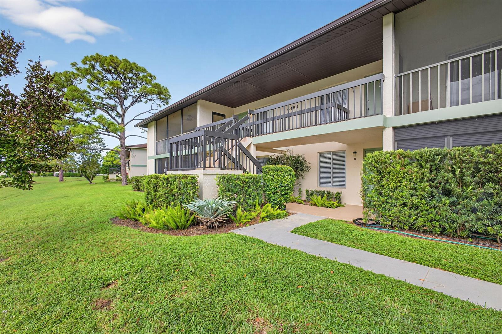 A two-story apartment building with a staircase, balcony, and landscaped lawn — 6485 Chasewood Drive # G, Jupiter FL 33458, JUPITER, FL