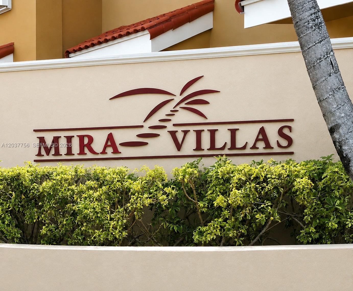 A sign for Mira Villas is mounted on a beige wall behind green bushes — 680 NW 82nd. Pl. # 261, Miami FL 33126, MIAMI, FL