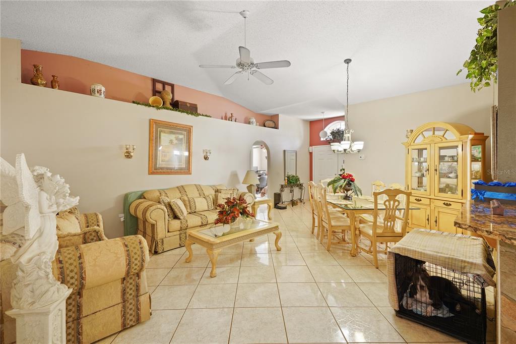 A living and dining room with tiled floors, vaulted ceilings, and a ceiling fan — 11545 BENTRY STREET, ORLANDO, FL