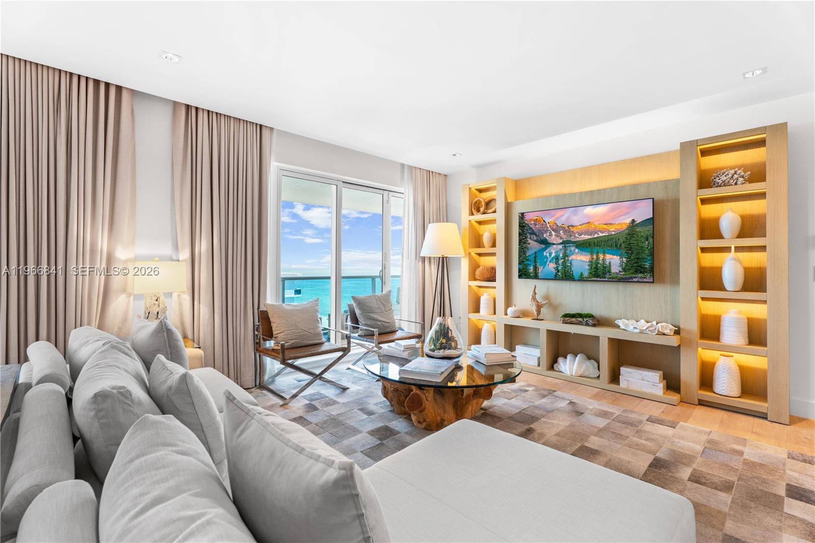A living room features a large sectional sofa, a wood-base coffee table, and ocean views — 102 24th St # 1705, Miami Beach FL 33139, MIAMI BEACH, FL