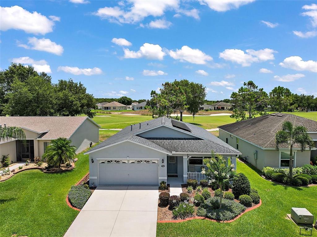 An aerial view of a single-story house with a two-car garage and golf course view — 27343 ROANOKE DRIVE, LEESBURG, FL