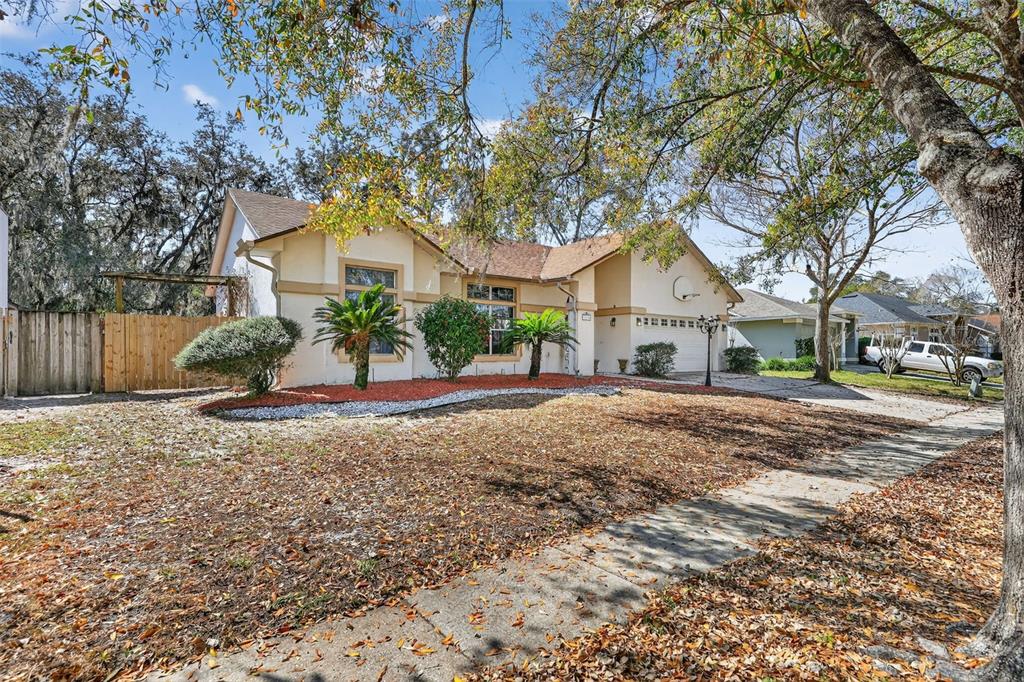 A single-story house with a tan stucco exterior, a two-car garage, and a front yard — 3236 PAISLEY CIRCLE, ORLANDO, FL