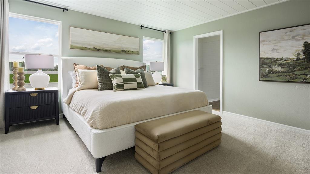 A bedroom features a white upholstered bed, a dark nightstand, and light green walls — 33561 NOBLE CREEK PLACE, DADE CITY, FL