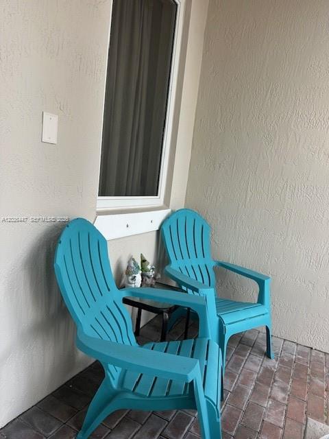 Two turquoise Adirondack chairs sit on a brick patio outside a window — 12444 SW 125th St, Miami FL 33186, MIAMI, FL