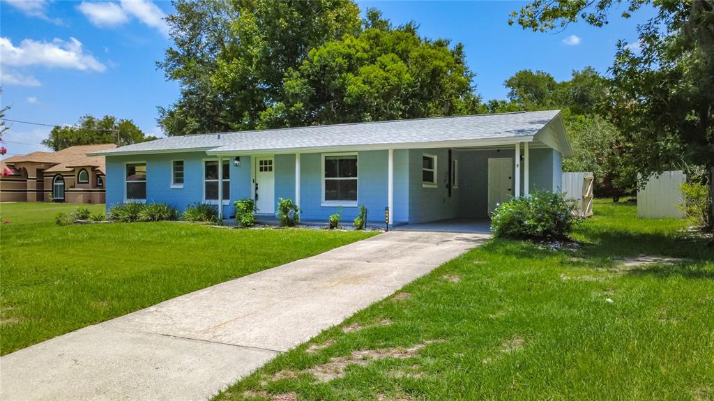 A single-story light blue house with a concrete driveway and an attached carport — 460 N PINE AVENUE, OVIEDO, FL