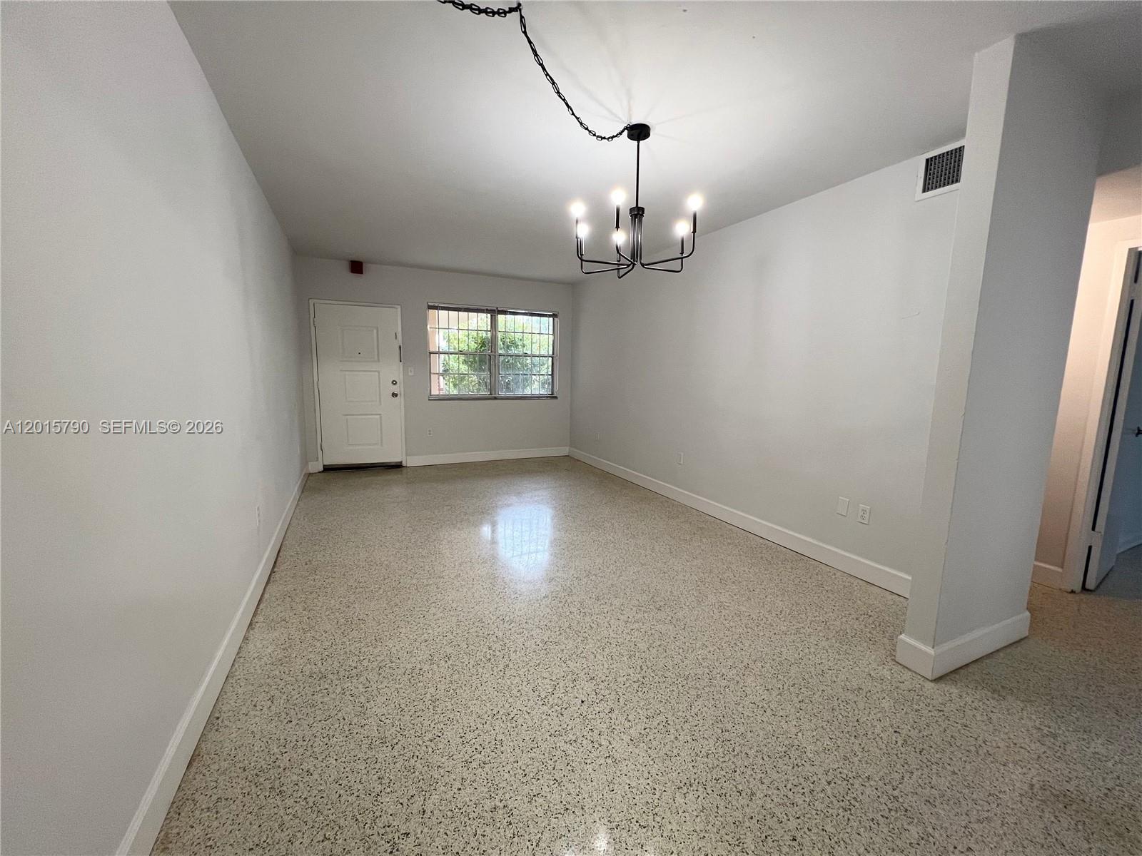 This room features light-colored walls, a chandelier, and speckled terrazzo flooring — 675 SW 7th Ave # 2, Miami FL 33130, MIAMI, FL
