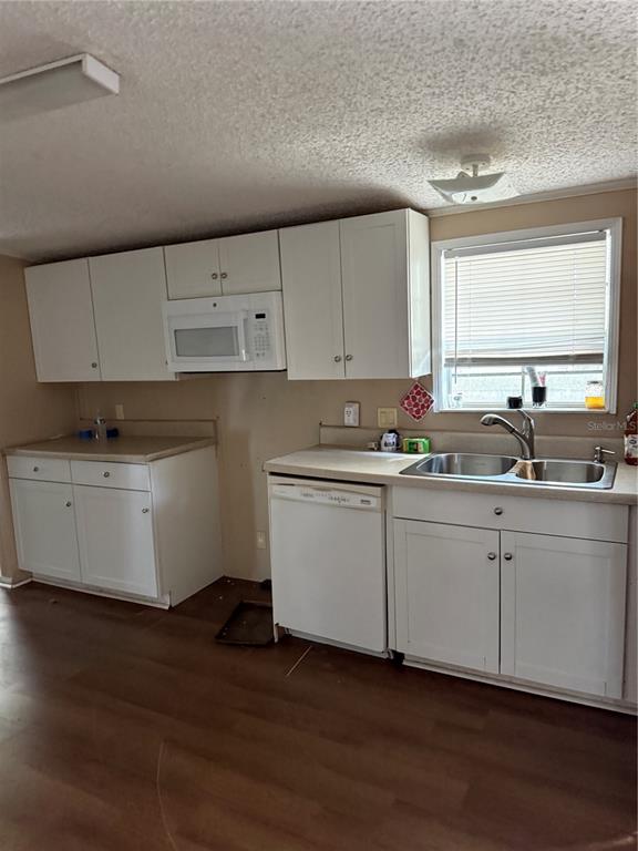 A kitchen with white cabinets, a built-in microwave, a dishwasher, and a double-basin sink — 14935 SE 47TH COURT, SUMMERFIELD, FL
