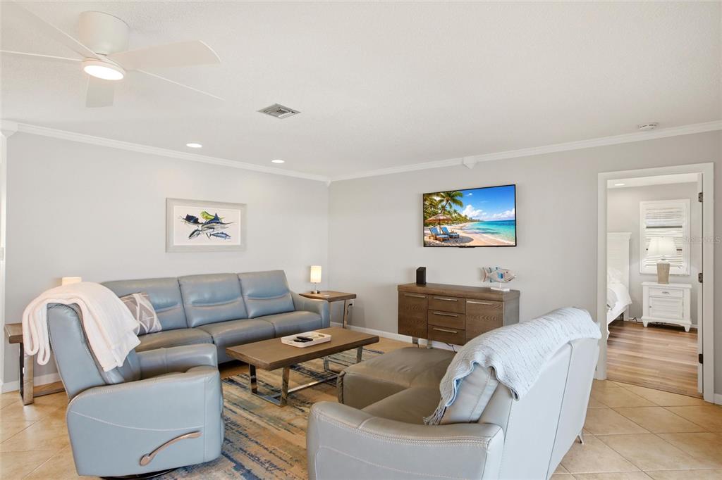 A living room features a blue leather sofa, a recliner, and a wooden media console — 79 TROPICANA DRIVE, PUNTA GORDA, FL