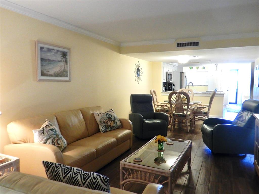 A living room with a leather sofa, two recliners, and a glass-topped coffee table — 103 1ST STREET E UNIT 210, TIERRA VERDE, FL