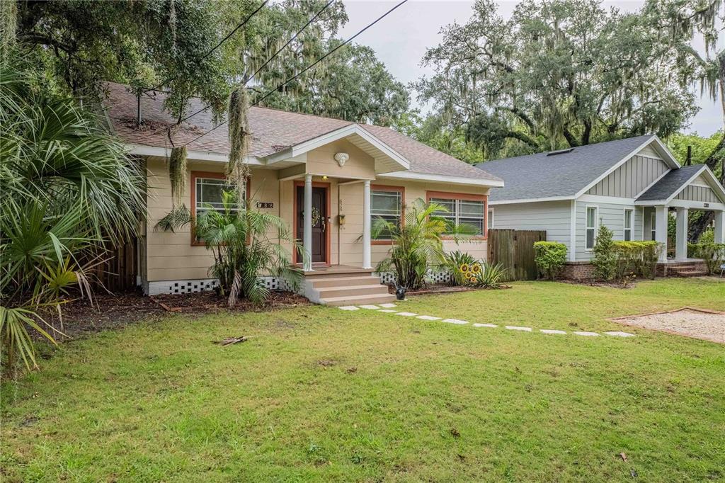 A tan, single-story bungalow with a front porch and a grassy yard — 828 OSCEOLA STREET, LAKELAND, FL