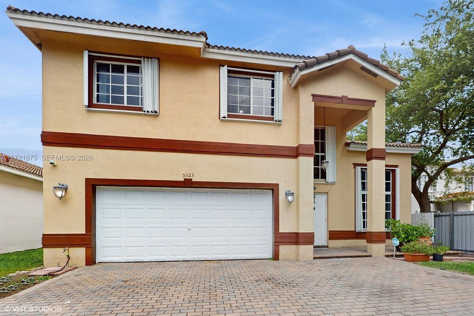 A two-story stucco house features a two-car garage and a paved driveway — 5323 NW 109th Ct, Doral FL 33178, DORAL, FL