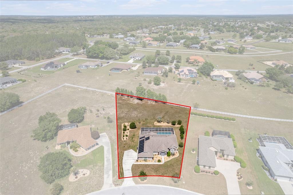 An aerial view shows a single-story house with a pool and solar panels on a lot — 1231 E WHIRL AWAY CIRCLE, INVERNESS, FL