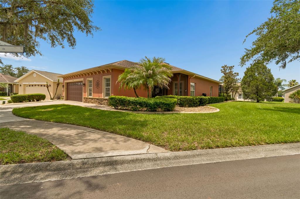 A single-story house with a terracotta-colored exterior, a two-car garage, and a manicured lawn — 218 BAY DRIVE, KISSIMMEE, FL
