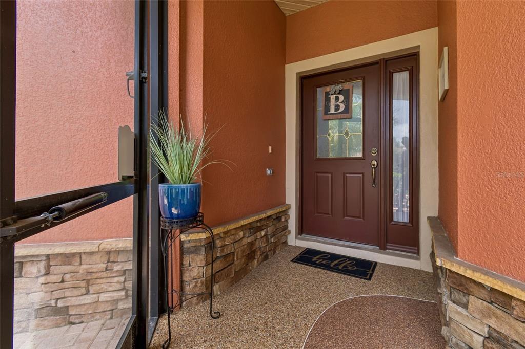 A front entryway features a brown door with a letter B sign and stone accents — 218 BAY DRIVE, KISSIMMEE, FL