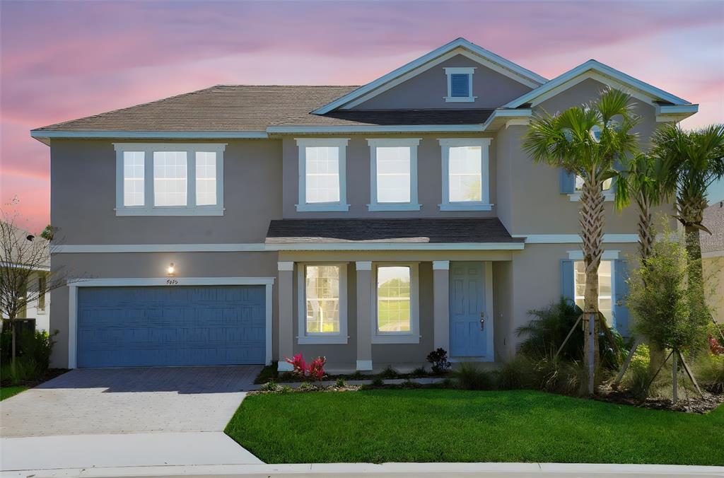 A two-story suburban house with a gray exterior, blue garage door, and a front lawn — 7445 SEA MANATEE STREET, PARRISH, FL
