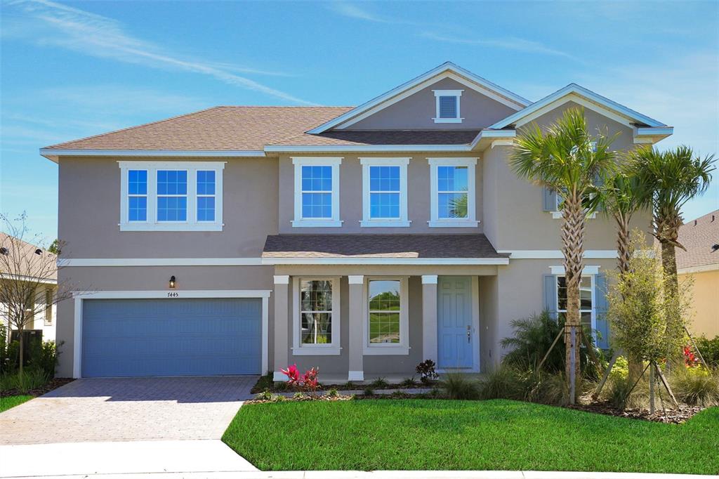 A two-story suburban house with a light blue garage door and front door — 7445 SEA MANATEE STREET, PARRISH, FL