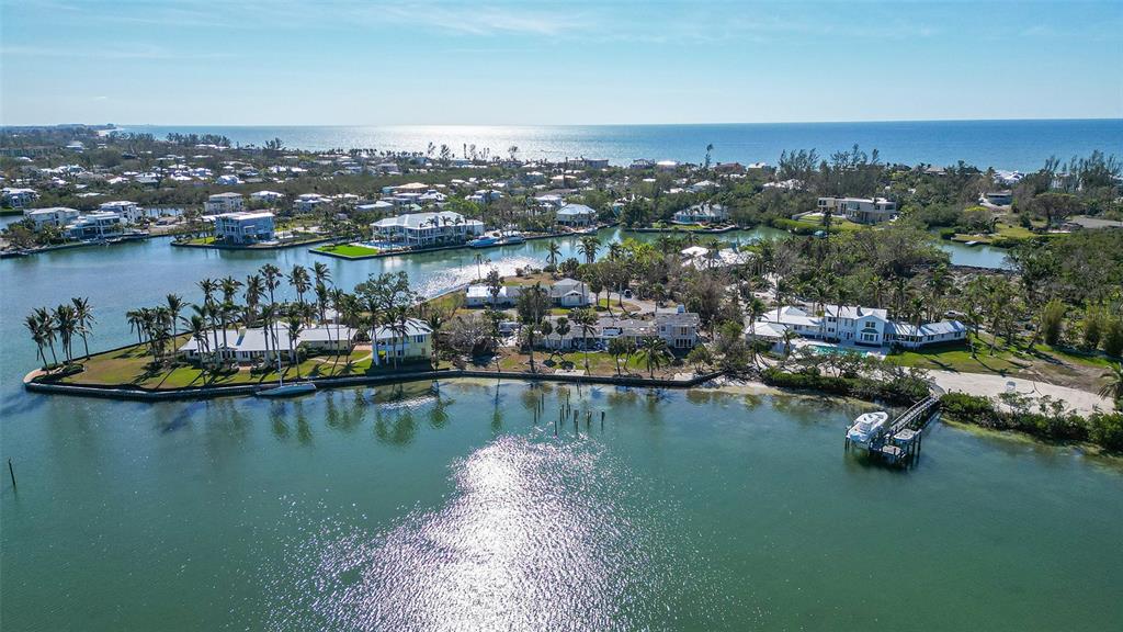 An aerial view of waterfront homes on a peninsula surrounded by a bay and ocean — 6516 BAYOU HAMMOCK ROAD, LONGBOAT KEY, FL