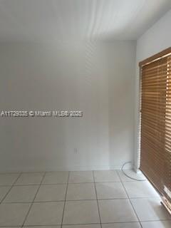 An empty room with white walls, light-colored tile flooring, and a window with wooden blinds — 1441 Lincoln Rd # 414, Miami Beach FL 33139, MIAMI BEACH, FL