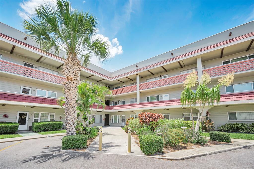 A three-story apartment building with a palm tree and a paved walkway in the courtyard — 2072 AUSTRALIA WAY W UNIT 32, CLEARWATER, FL