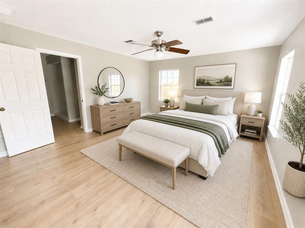 A bedroom features a bed with green bedding, a wooden dresser, and light wood flooring — 5910 BAKER ROAD, NEW PORT RICHEY, FL