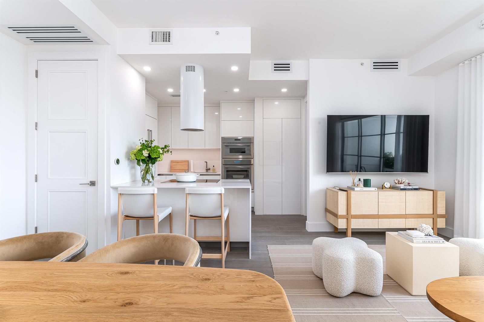 A modern open-concept kitchen and living area featuring white cabinetry, a breakfast bar, and television — 155 E Boca Raton Road # 1008, Boca Raton FL 33432, BOCA RATON, FL