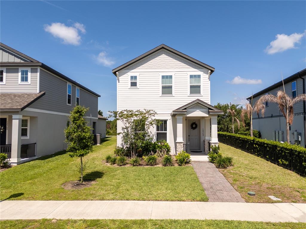 A two-story house with white siding, a front porch, and a paved walkway — 12362 BRACCO STREET, WINTER GARDEN, FL