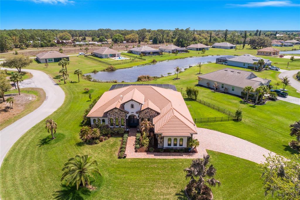 An aerial view of a single-story house with a tiled roof and a paved driveway — 17210 SERENGETI CIRCLE, ALVA, FL