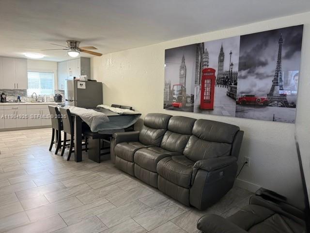 A living room with a gray reclining sofa, dining table, and a large wall mural — 6278 W 22nd Ct # 5, Hialeah FL 33016, HIALEAH, FL