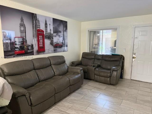 A living room features two gray leather sofas and a large wall mural of London — 6278 W 22nd Ct # 5, Hialeah FL 33016, HIALEAH, FL