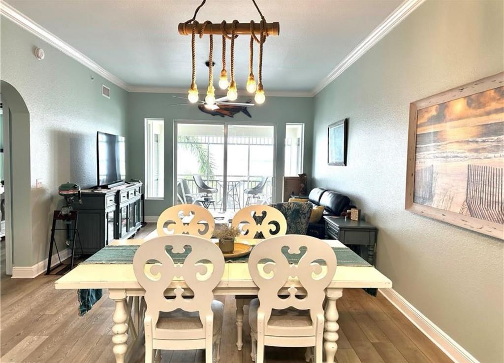 A dining area features a white table with decorative chairs under a rope chandelier — 5114 MELBOURNE STREET UNIT A302, PUNTA GORDA, FL