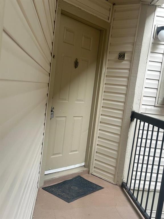 An exterior view of a beige apartment door marked with the number 93 — 1940 LAKE ATRIUMS CIRCLE UNIT 93, ORLANDO, FL