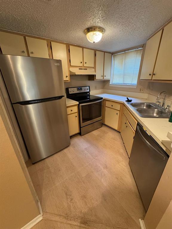 A kitchen featuring light-colored cabinets, stainless steel appliances, and a window above the sink — 1940 LAKE ATRIUMS CIRCLE UNIT 93, ORLANDO, FL