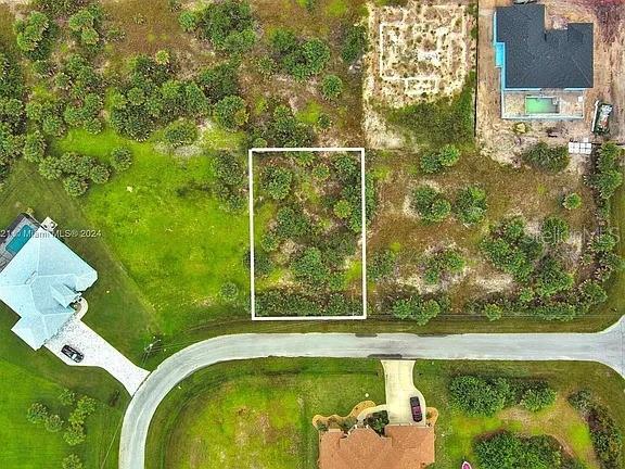 An aerial view shows a vacant rectangular lot outlined in white within a residential neighborhood — 10705 RAINSVILLE STREET, PORT CHARLOTTE, FL