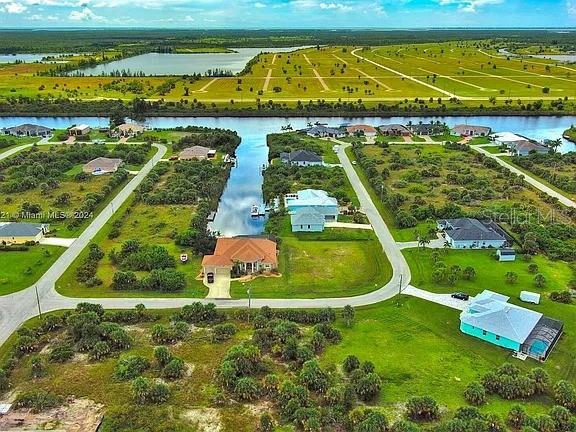 This aerial view shows houses situated along a canal in a residential development — 10705 RAINSVILLE STREET, PORT CHARLOTTE, FL