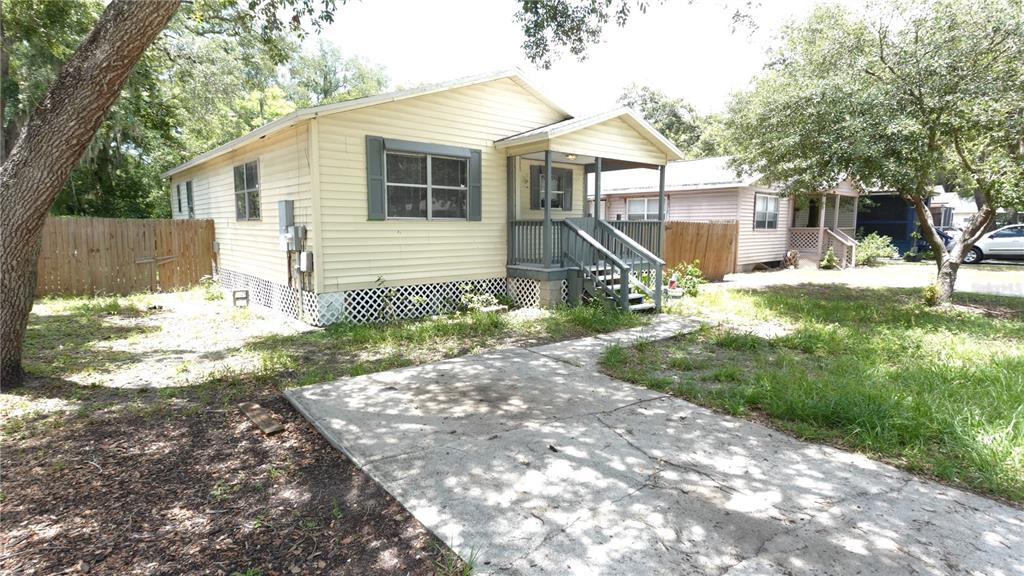 A light yellow house with a front porch and a concrete driveway sits on a lot — 3110 GORDON COURT, TAMPA, FL