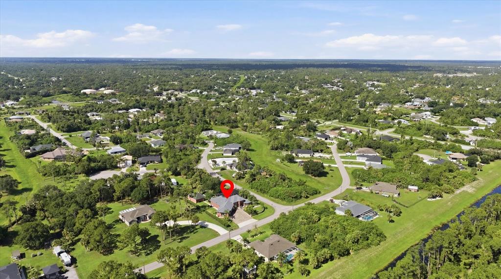 An aerial view shows a residential neighborhood with a red pin marking a house — 3257 WENONA DRIVE, NORTH PORT, FL