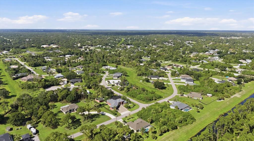 An aerial view shows a residential neighborhood with houses surrounded by trees and green lawns — 3257 WENONA DRIVE, NORTH PORT, FL
