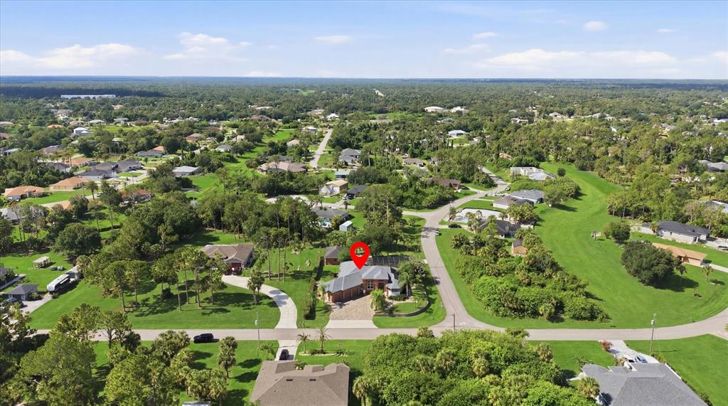 An aerial view shows a single-story house with a pool cage in a suburban neighborhood — 3257 WENONA DRIVE, NORTH PORT, FL