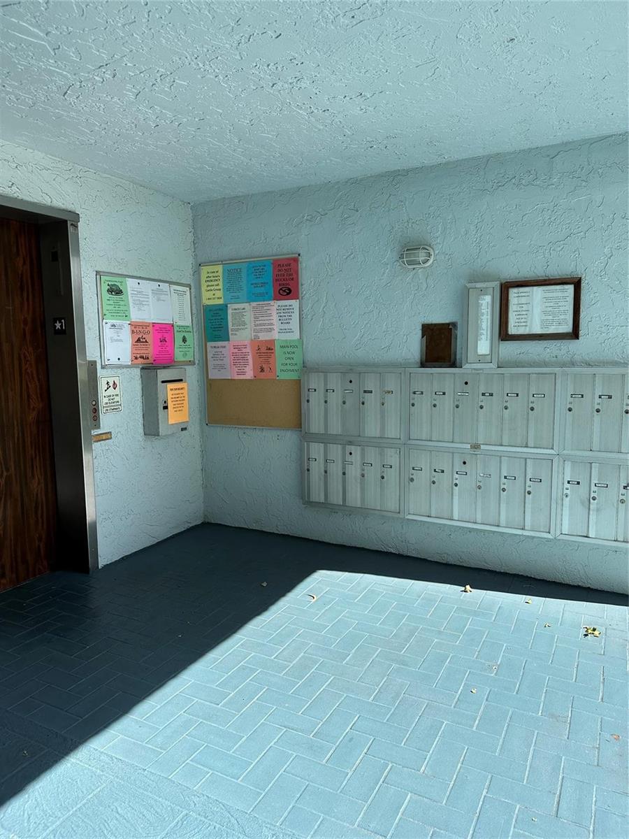 An empty living room with tan walls, large beige floor tiles, and a sliding glass door — 7680 NW 18th Street # 406, Margate FL 33063, MARGATE, FL