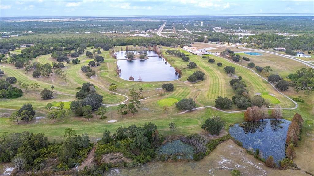An aerial view shows a golf course with two ponds and surrounding wooded areas — 0 ALLAMANDA DRIVE, INDIAN LAKE ESTATES, FL