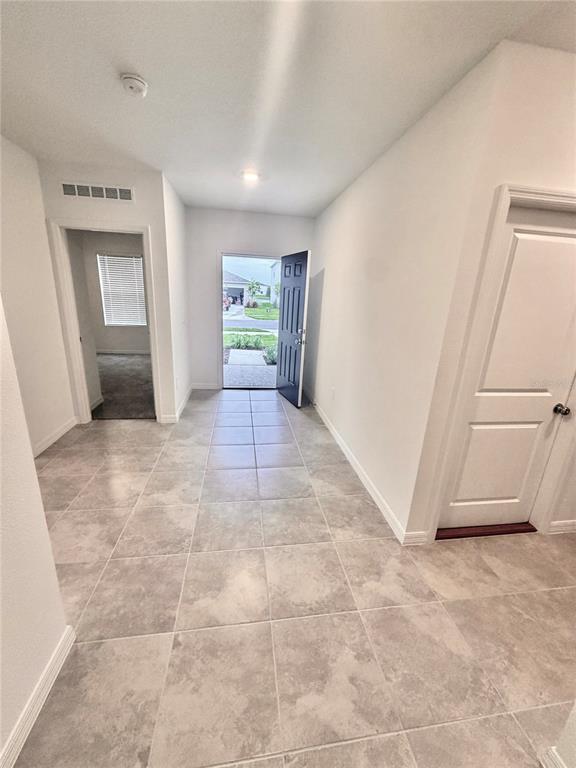 A tiled entryway features a dark front door, a side doorway, and a closet door — 5443 ISLA SAONA DRIVE, KISSIMMEE, FL