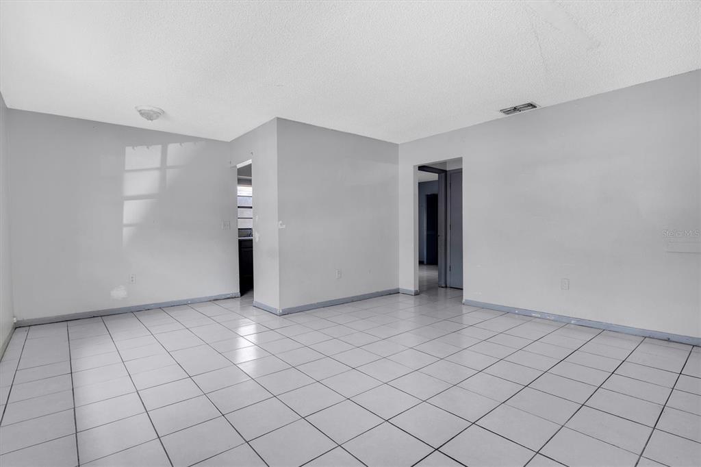 An empty room with white walls, a tiled floor, and two doorways — 2464 CHESTNUT WOODS DRIVE, LAKELAND, FL