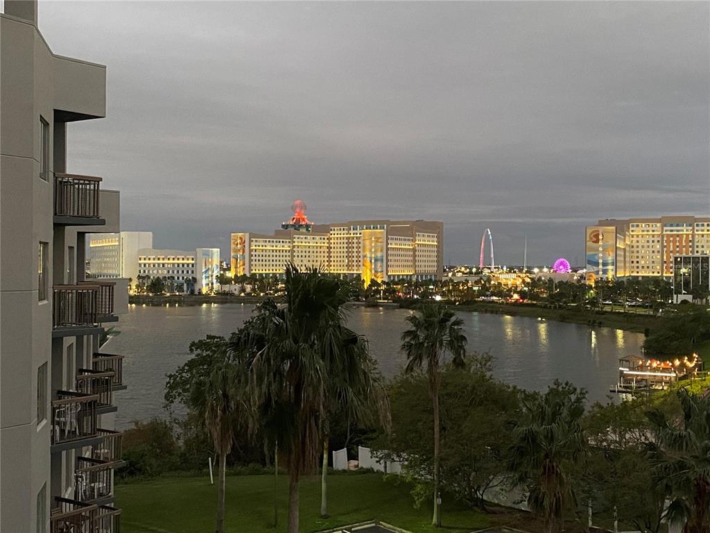 An exterior view of a lakefront hotel complex with a Ferris wheel and skyline — 6165 CARRIER DRIVE UNIT 2602, ORLANDO, FL