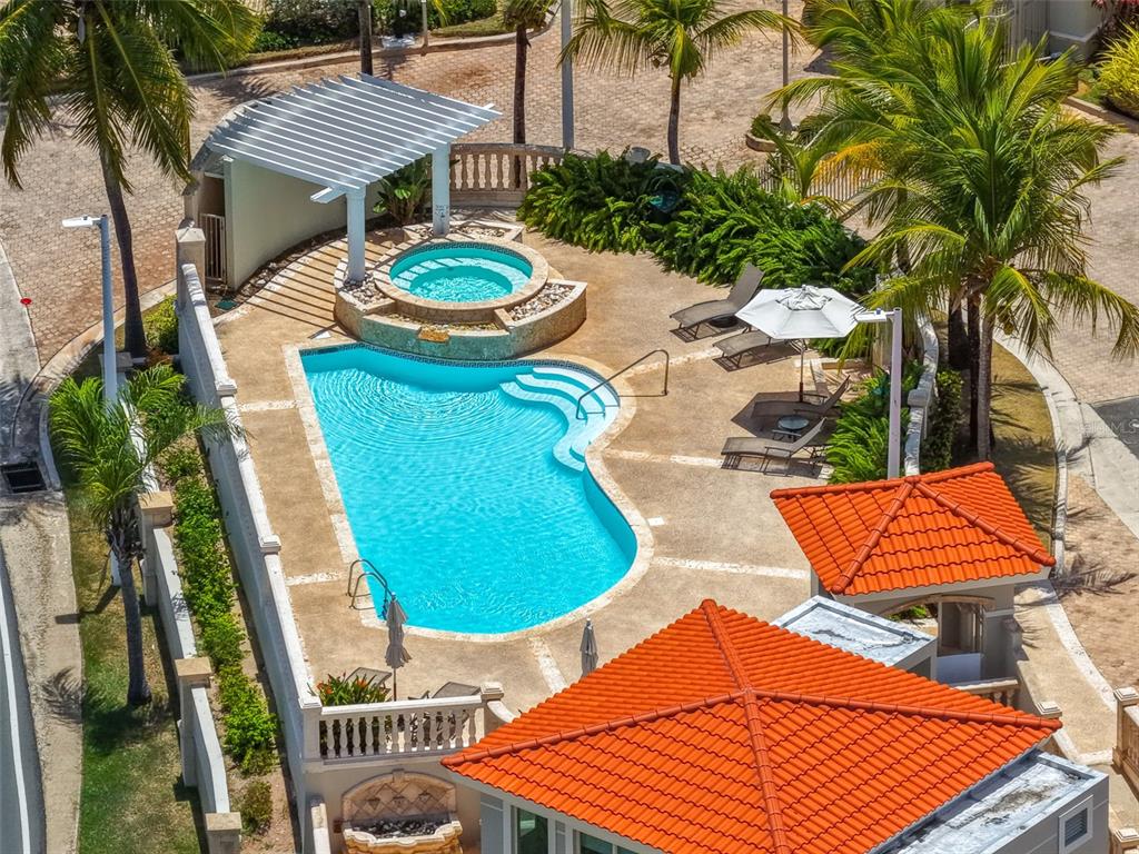 An aerial view of a swimming pool and hot tub with a pergola and patio — 285 PALMAS INN WAY CORNER SE UNIT 1303, HUMACAO, PR
