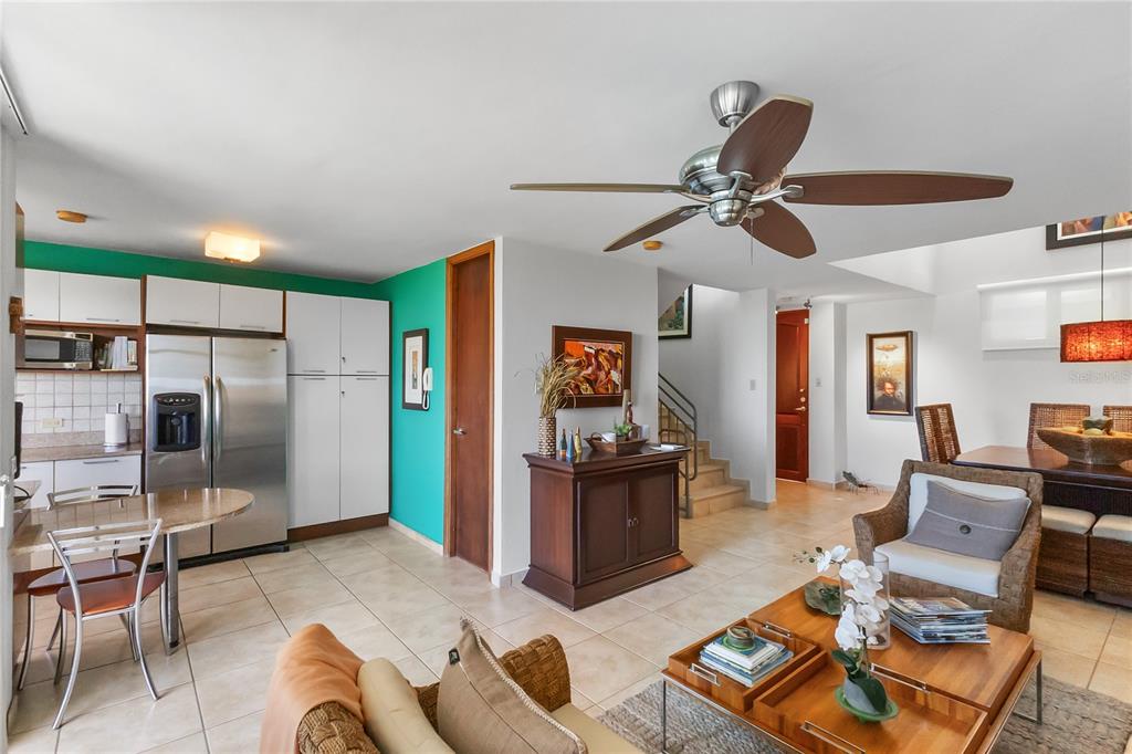 An open-concept living and dining area features tile flooring, a teal accent wall, and cabinetry — 285 PALMAS INN WAY CORNER SE UNIT 1303, HUMACAO, PR