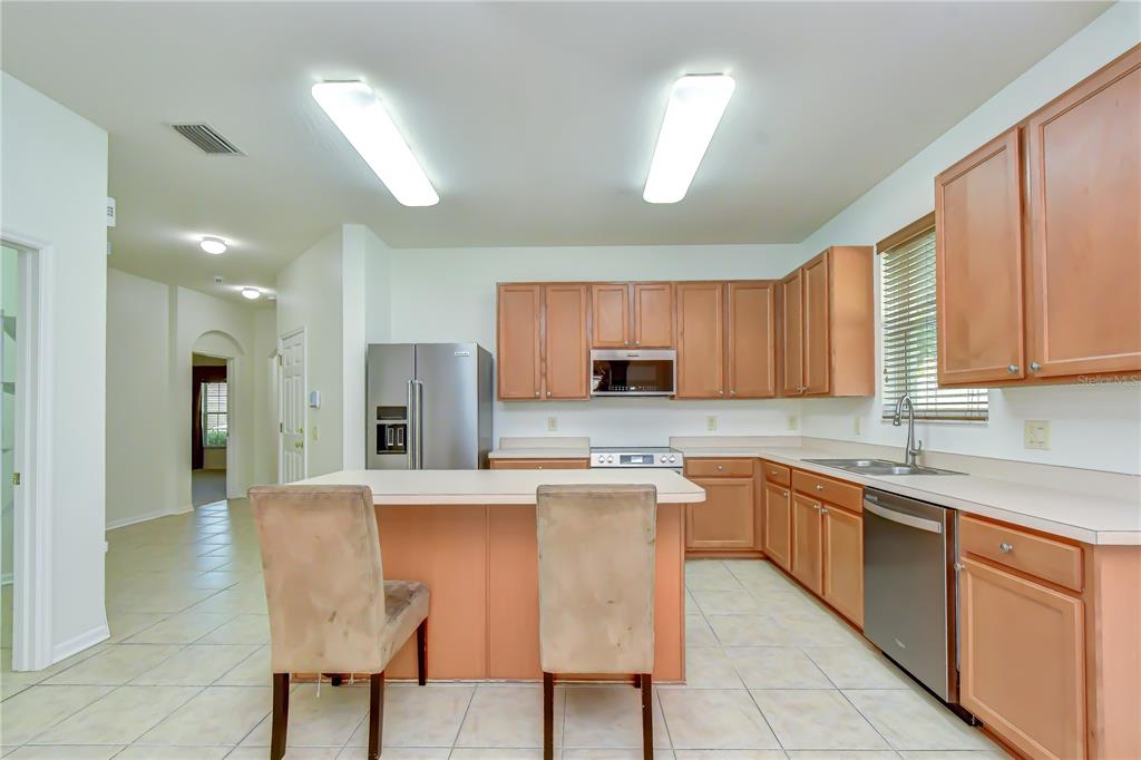 A kitchen with light wood cabinets, a central island, and tile flooring — 426 SUMMERLYN DRIVE, VALRICO, FL
