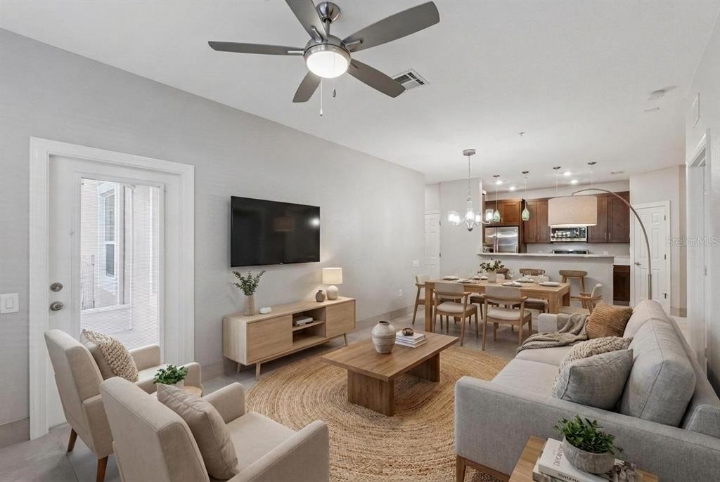A living room with a ceiling fan, television, and dining area in an open floor plan — 2484 SAN TECLA STREET UNIT 105, ORLANDO, FL
