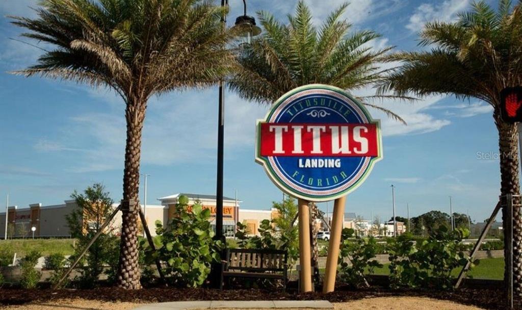 A large circular sign for Titus Landing stands between two palm trees in a parking lot — 0 WESTWOOD DRIVE, TITUSVILLE, FL