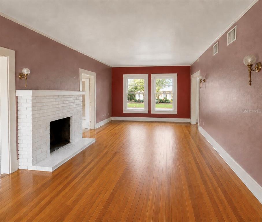A living room features hardwood floors, a white brick fireplace, and red accent walls — 4535 9TH AVENUE N, ST PETERSBURG, FL